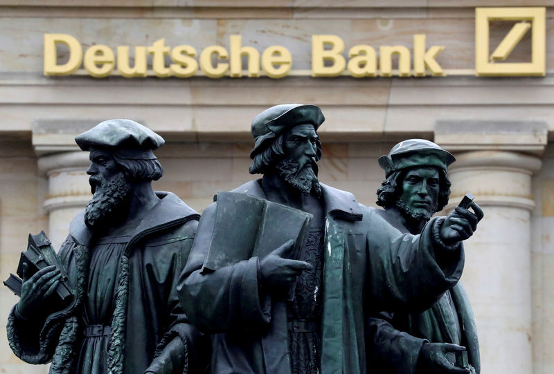 © Reuters. FILE PHOTO: A statue is pictured next to the logo of Germany's Deutsche Bank in Frankfurt