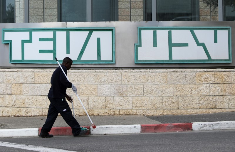 © Reuters. A man cleans near the logo of Teva Pharmaceutical Industries at their plant in Jerusalem