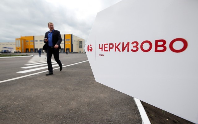 © Reuters. Человек проходит мимо логотипа Черкизово на предприятии Тамбовская индейка под Тамбовом