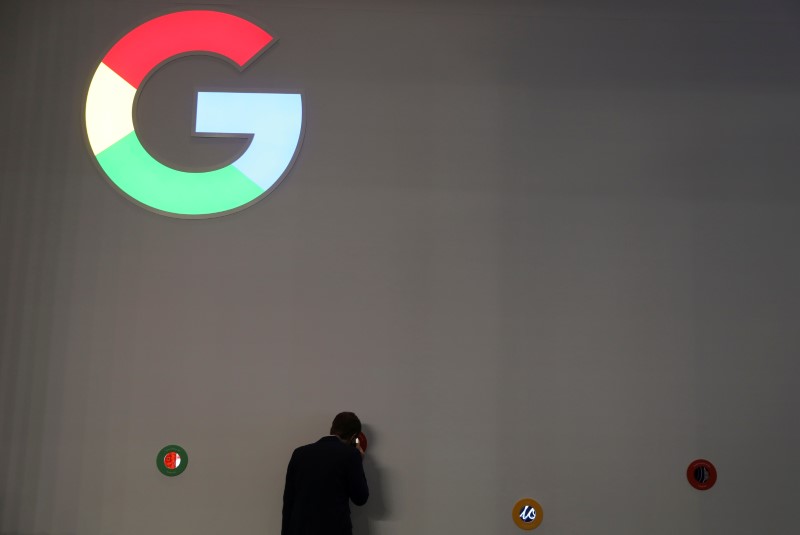 © Reuters. A man checks Google devices outside its booth at the Mobile World Congress in Barcelona