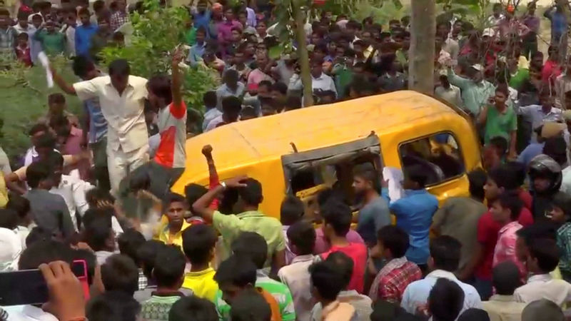 © Reuters. Pessoas se aglomeram em volta de van escolar após acidente com trem em Uttar Pradesh, na Índia