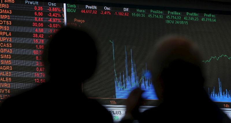 © Reuters. Pessoas olham gráfico de flutuações do mercado na Bovespa, São Paulo, Brasil