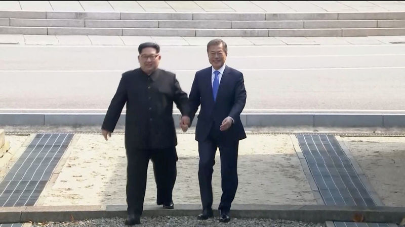 © Reuters. North Korean leader Kim Jong Un and South Korean President Moon Jae-in walk across the military demarcation line ahead of the inter-Korean summit at the truce village of Panmunjom, in this still frame taken from video