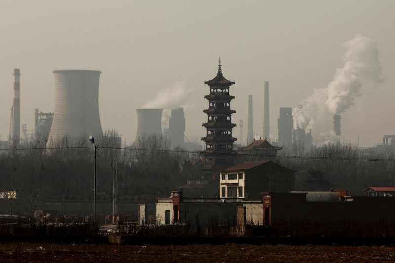 © Reuters. Cooling towers emit steam and chimneys billow in an industrial zone in Wu'an