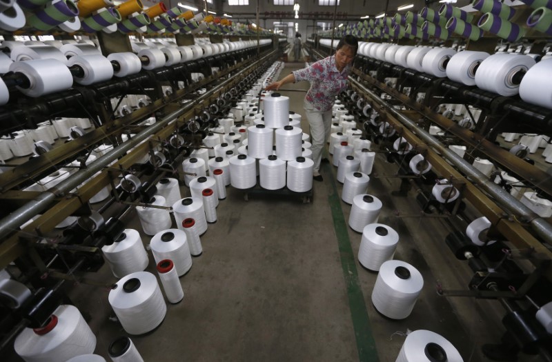 © Reuters. An employee works inside a textile factory in Linhai, Zhejiang province