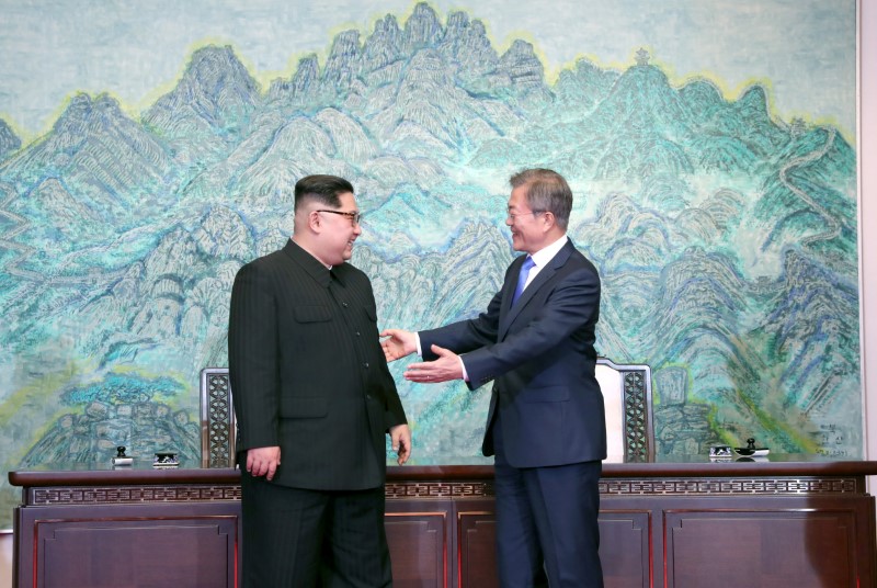 © Reuters. Il presidente sudcoreano Moon Jae-in (a destra) e il leader nordcoreano Kim Jong Un oggi, nel villaggio di Panmunjom