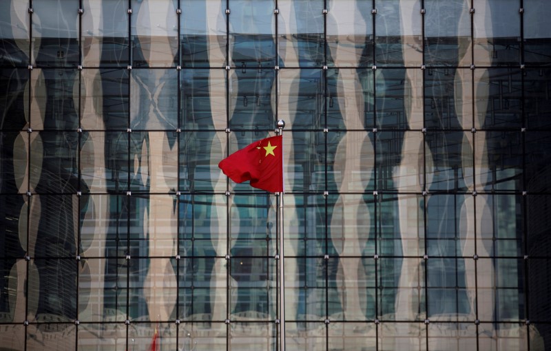 © Reuters. FILE PHOTO: A Chinese national flag flutters at the headquarters of a commercial bank on a financial street in central Beijing