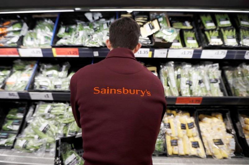 © Reuters. FILE PHOTO: A Sainsbury's worker stacks a vegetable shelf in a store in Redhill