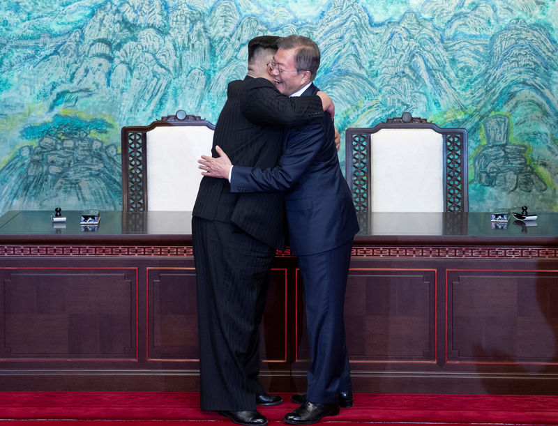 © Reuters. South Korean President Moon Jae-in and North Korean leader Kim Jong Un embrace at the truce village of Panmunjom