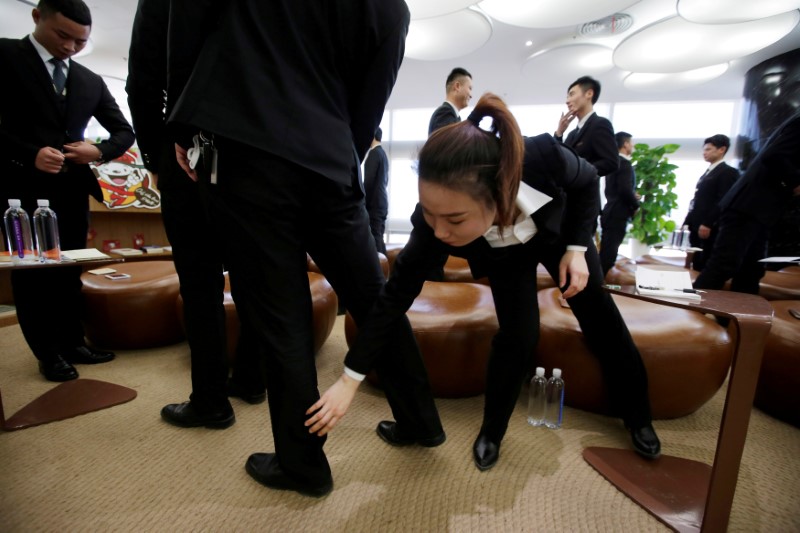 © Reuters. FILE PHOTO: Members of JD.com's VIP delivery team attend a training session on business etiquette at the company headquarters in Beijing