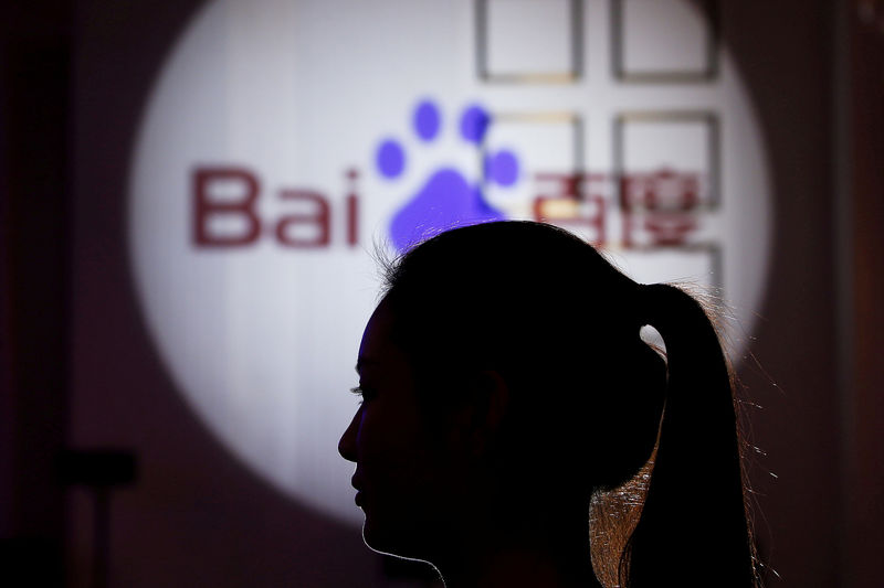 © Reuters. FILE PHOTO: A woman is silhouetted against the Baidu logo at a new product launch from Baidu, in Shanghai, China