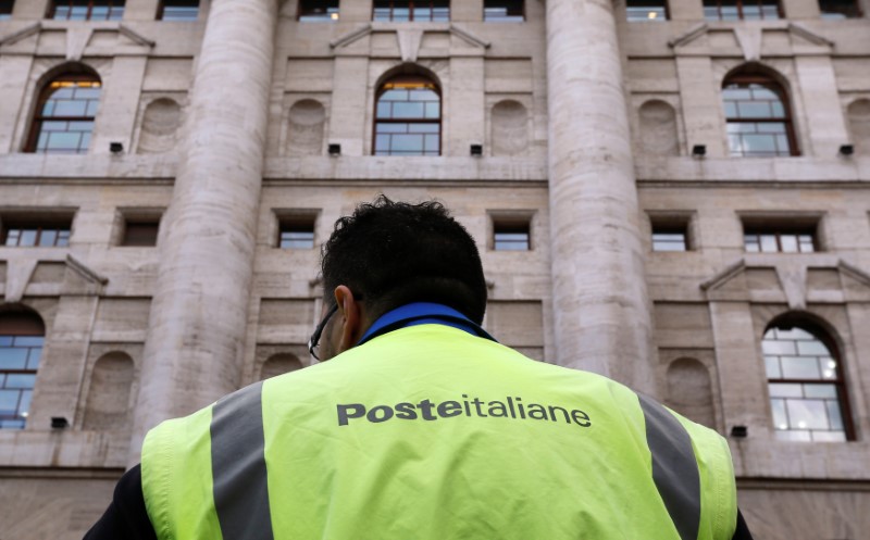 © Reuters. Un lavoratore di Poste Italiane davanti alla borsa di Milano