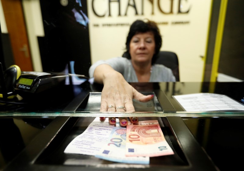 © Reuters. Woman exchanges forints for euros at currency exchange shop in Esztergom