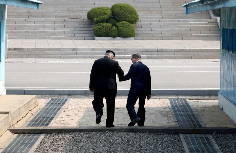 © Reuters. I leader delle due Coreee, Moon Jae-in e Kim Jong durante l'incontro della settimana scorsa a Panmunjom