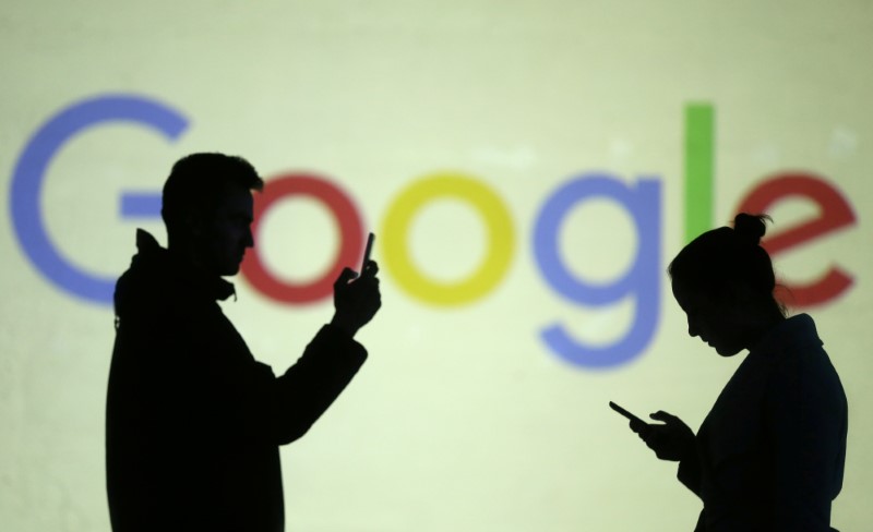 © Reuters. Silhuetas em frente ao logo do Google em fotoilustração