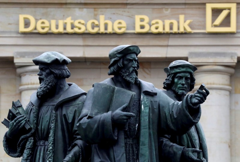 © Reuters. FILE PHOTO: FILE PHOTO: A statue is pictured next to the logo of Germany's Deutsche Bank in Frankfurt