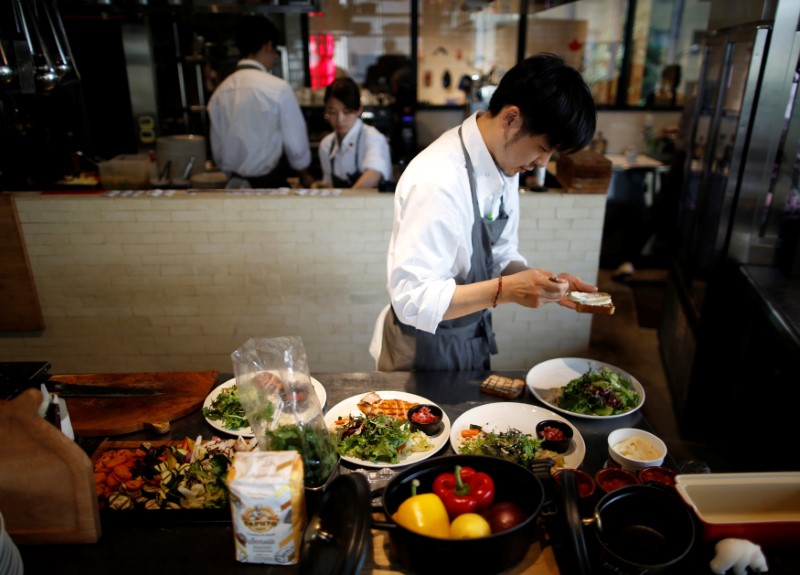 © Reuters. Chefs prepare dishes at HyLife Pork Table in Tokyo