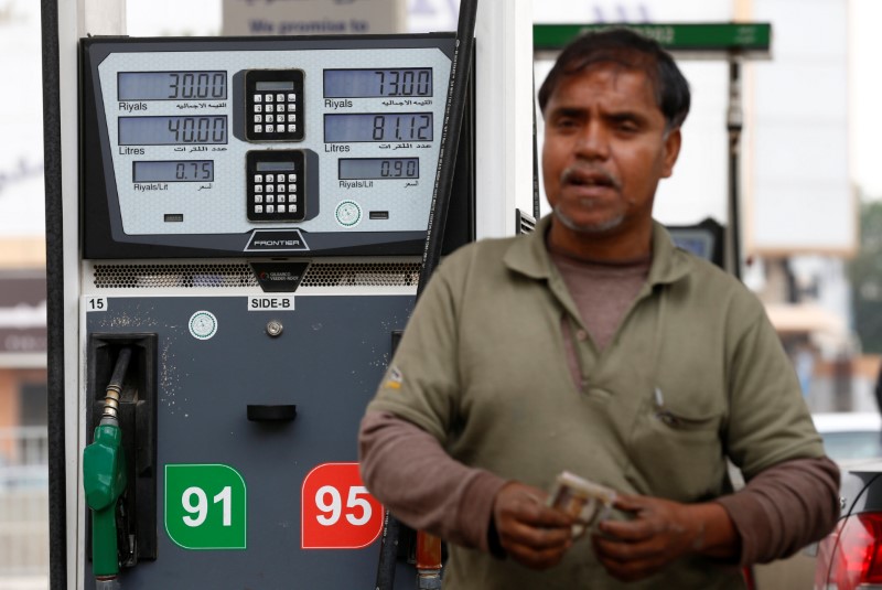 © Reuters. A worker stands in front of a fuel pump at a petrol station in Riyadh