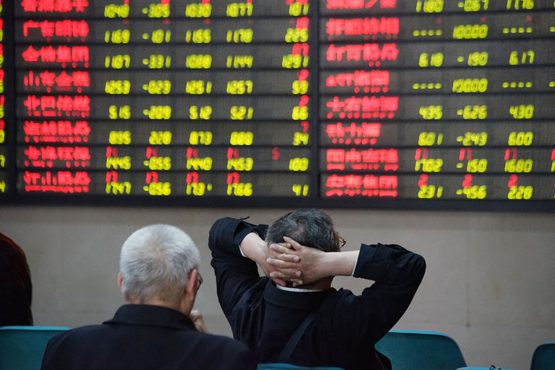 © Reuters. Investors look at an electronic board showing stock information at a brokerage house in Nanjing