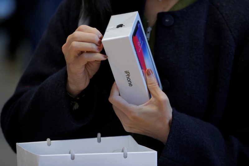 © Reuters. A customer looks at her Apple iPhone X at an Apple store in New York