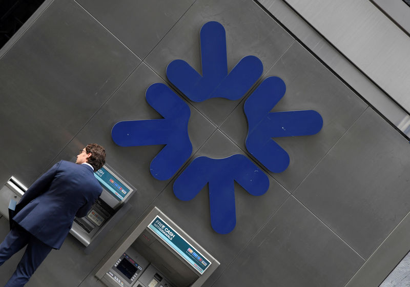 © Reuters. FILE PHOTO: A customer uses an ATM at a branch of RBS bank in the City of London financial district in London