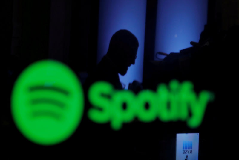 © Reuters. FILE PHOTO: A trader is reflected in a computer screen displaying the Spotify brand before the company begins selling as a direct listing on the floor of the New York Stock Exchange in New York