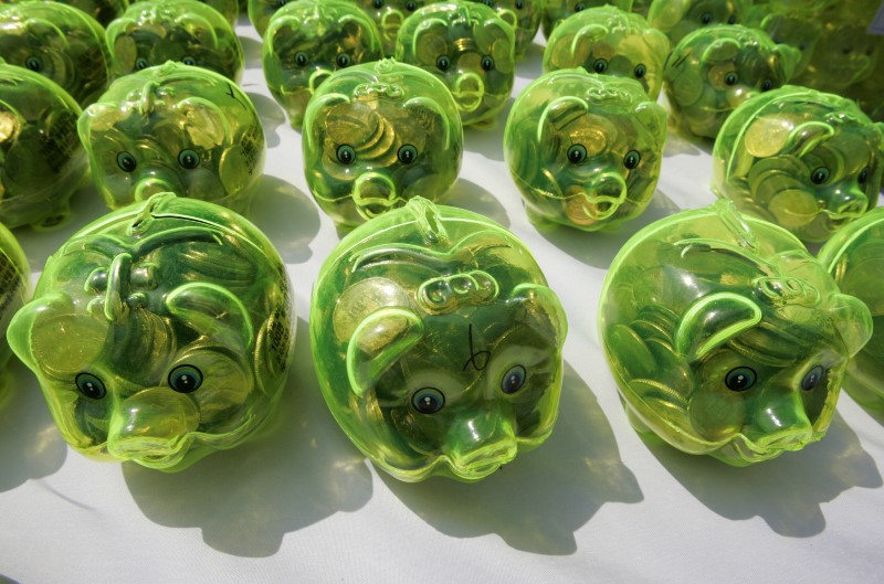 © Reuters. Piggy banks filled with money are displayed on a desk during a "Save our economy" campaign by Korea Saemaulundong Centre in Seoul