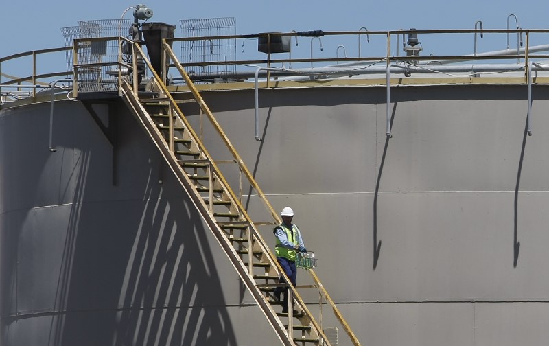 © Reuters. A man walks down the stairs of a petrol storage tank at an oil refinery in Melbourne