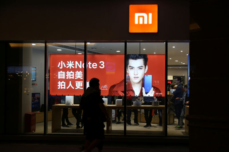 © Reuters. People walk past a Xiaomi store in Beijing