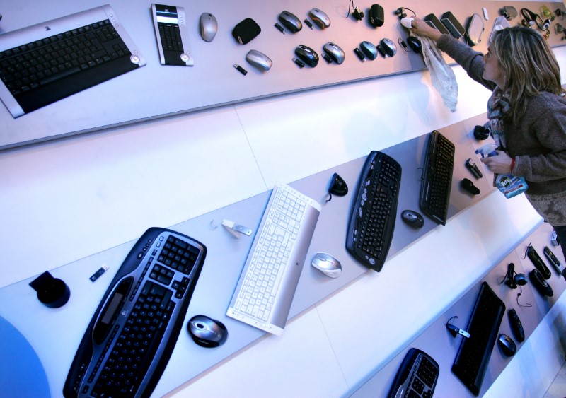 © Reuters. Vendedora limpa display de teclados e mouses da Logitech