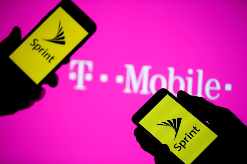 © Reuters. FILE PHOTO: Smartphones with Sprint logo are seen in front of a screen projection of T-mobile logo, in this picture illustration