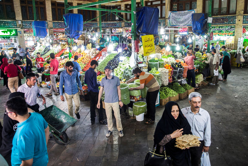 © Reuters. FILE PHOTO: People buy vegetables and fruits at the Tajrish Bazaar in northern part of Tehran