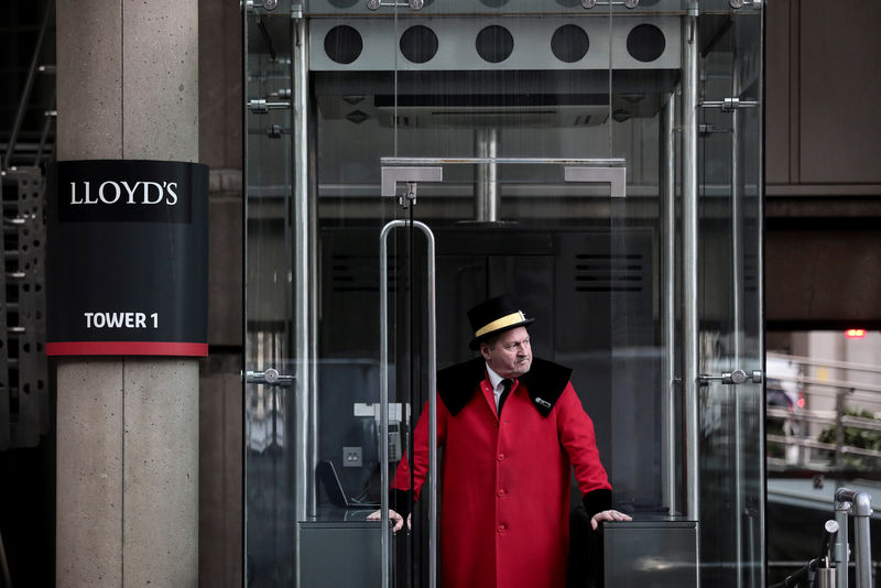 © Reuters. FILE PHOTO: A doorman stands outside the Lloyd's of London building in the City of London financial district in London