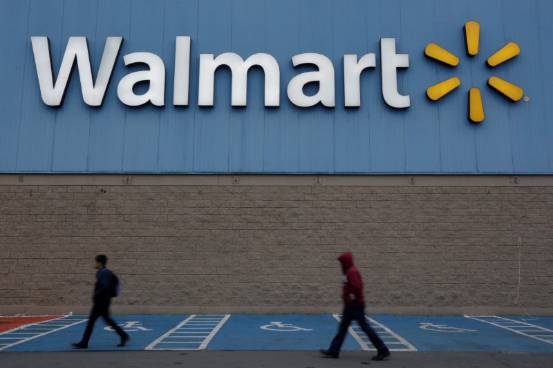 © Reuters. Homens passam pelo logo do Walmart em loja do grupo varejista