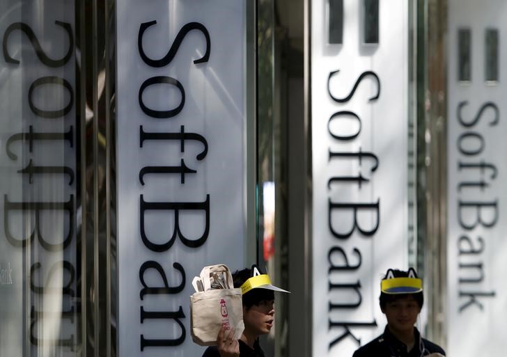 © Reuters. FILE PHOTO: Shop employees of SoftBank Corp work outside its branch in Tokyo