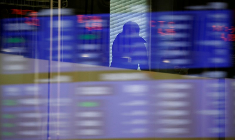 © Reuters. FILE PHOTO: A visitor is seen as market prices are reflected in a glass window at the TSE in Tokyo