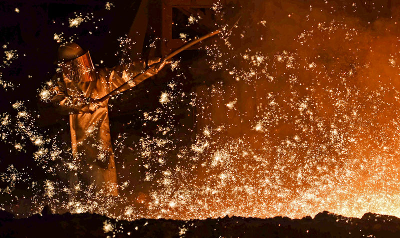 © Reuters. FILE PHOTO: A steel-worker is pictured at a furnace at the plant of German steel company Salzgitter AG in Salzgitter