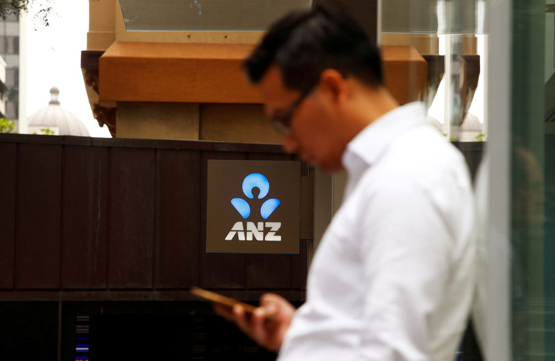 © Reuters. FILE PHOTO: A man uses his mobile phone in front of an ANZ bank branch in central Sydney