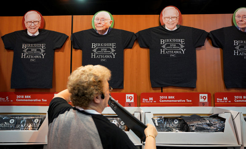 © Reuters. FILE PHOTO:    A worker arranges a display of t-shirts with images of Warren Buffett and Charlie Munger at the Berkshire Hathaway Inc annual meeting, the largest in corporate America, in its hometown of Omaha