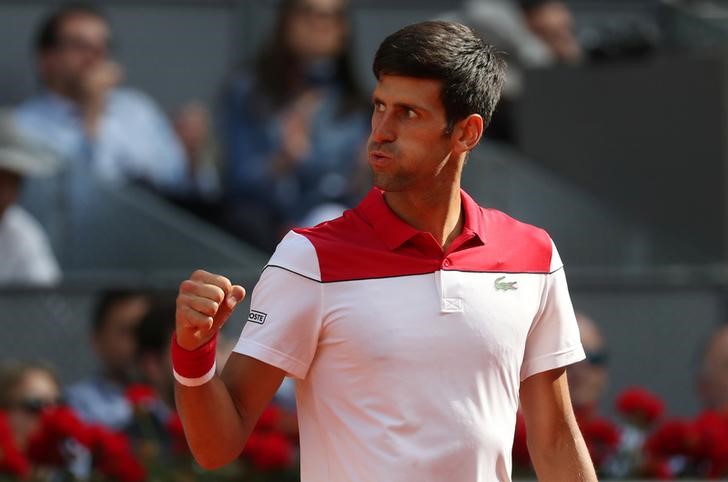 © Reuters. El tenista serbio Novak Djokovic festeja al derrotar al japonés Kei Nishikori en su encuentro por el Abierto de  Madrid