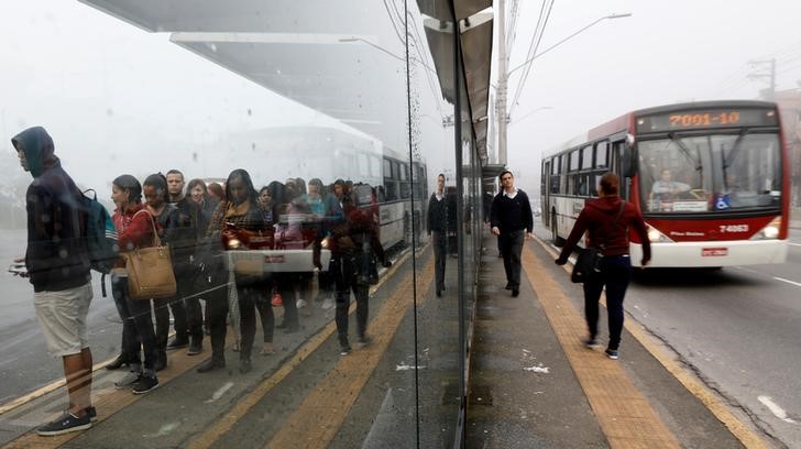 © Reuters. Passageiros esperam em ponto de ônibus em São Pualo