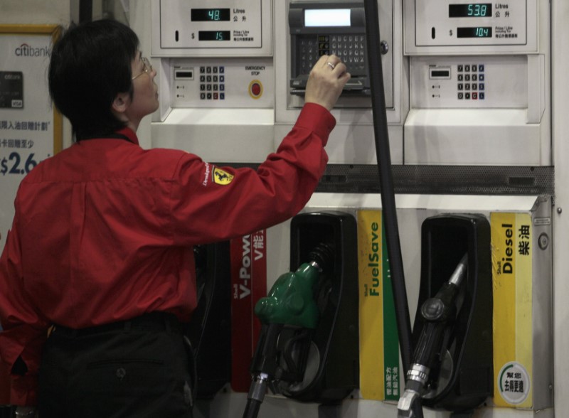 © Reuters. A worker checks the price of fuel at a gas station in Hong Kong