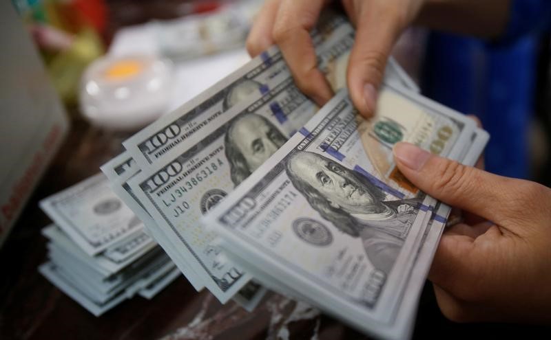 © Reuters. An employee of a bank counts US dollar notes at a branch in Hanoi