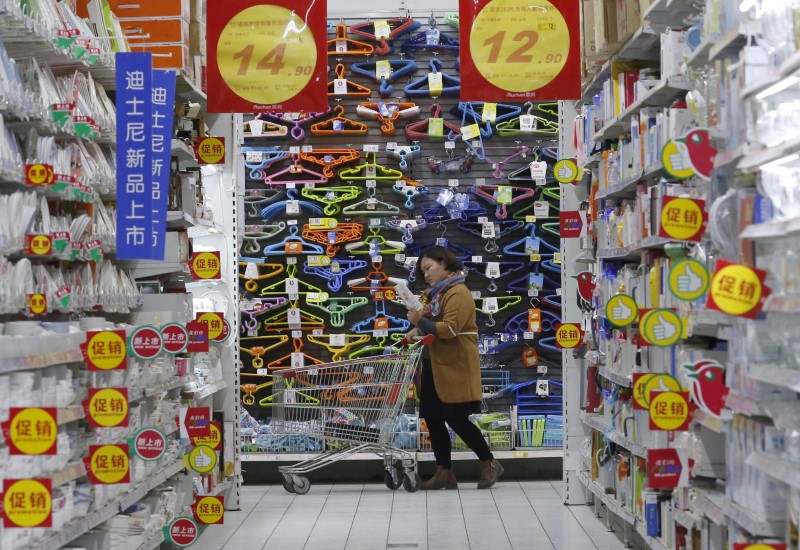 © Reuters. FILE PHOTO: A customer pushes a shopping cart at Sun Art Retail Group's Auchan hypermarket store in Beijing