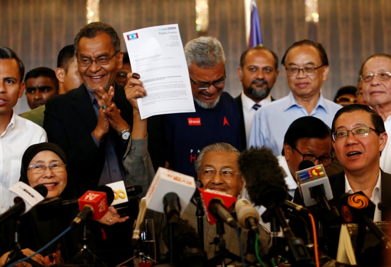 © Reuters. Mahathir Mohamad holds up a document during a news conference following the general election in Petaling Jaya