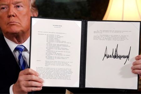 © Reuters. Il presidente Usa Donald Trump mostra il documento con cui ha dichiarato l'intenzione di annullare l'accordo con l'Iran sul nucleare