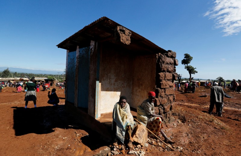 © Reuters. Survivors sit outside their destroyed house after a dam burst, which unleashed water at nearby homes, in Solio town near Nakuru