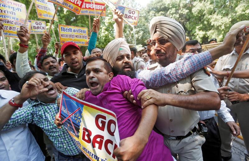 © Reuters. Activists from Swadeshi Jagran Manch, a wing of Hindu nationalist organisation RSS scuffle with police during a protest against U.S. retailer Walmart’s majority stake buy in Indian e-commerce firm Flipkart, in New Delhi