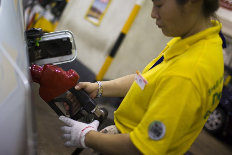 © Reuters. A petrol station employee pumps fuel into a vehicle in Hong Kong's Wan Chai district