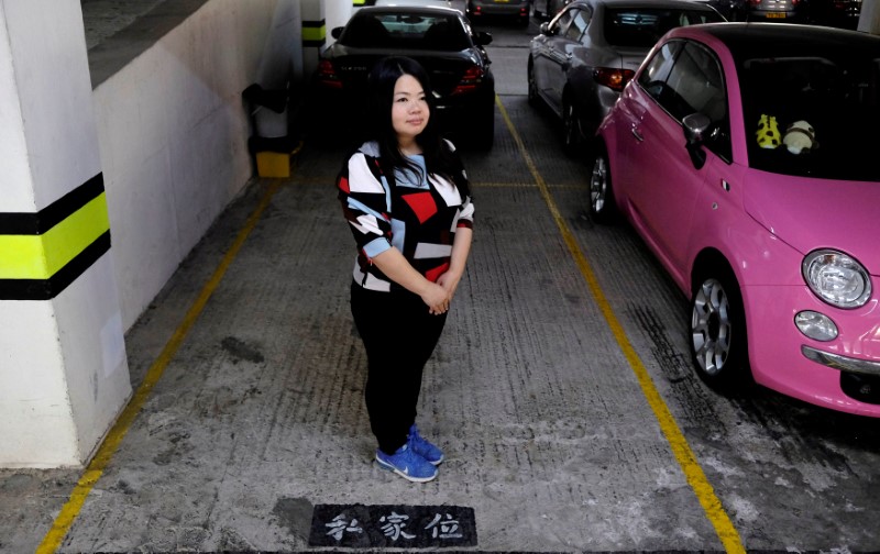 © Reuters. Insurance agent Esther Fan poses with a parking spot she bought as an investment in Hong Kong